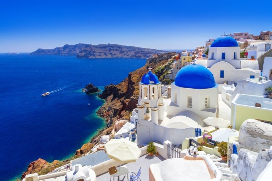 iconic white-washed buildings overlooking the azure waters of Santorini